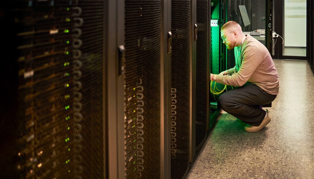 Technician maintaining servers on graphene-enhanced conductive flooring with intrinsic ESD protection in hyperscale datacenter facility