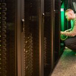 Technician maintaining servers on graphene-enhanced conductive flooring with intrinsic ESD protection in hyperscale datacenter facility
